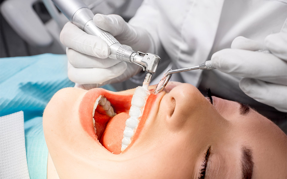  Dental hygienist performing a professional teeth cleaning procedure on a patient.