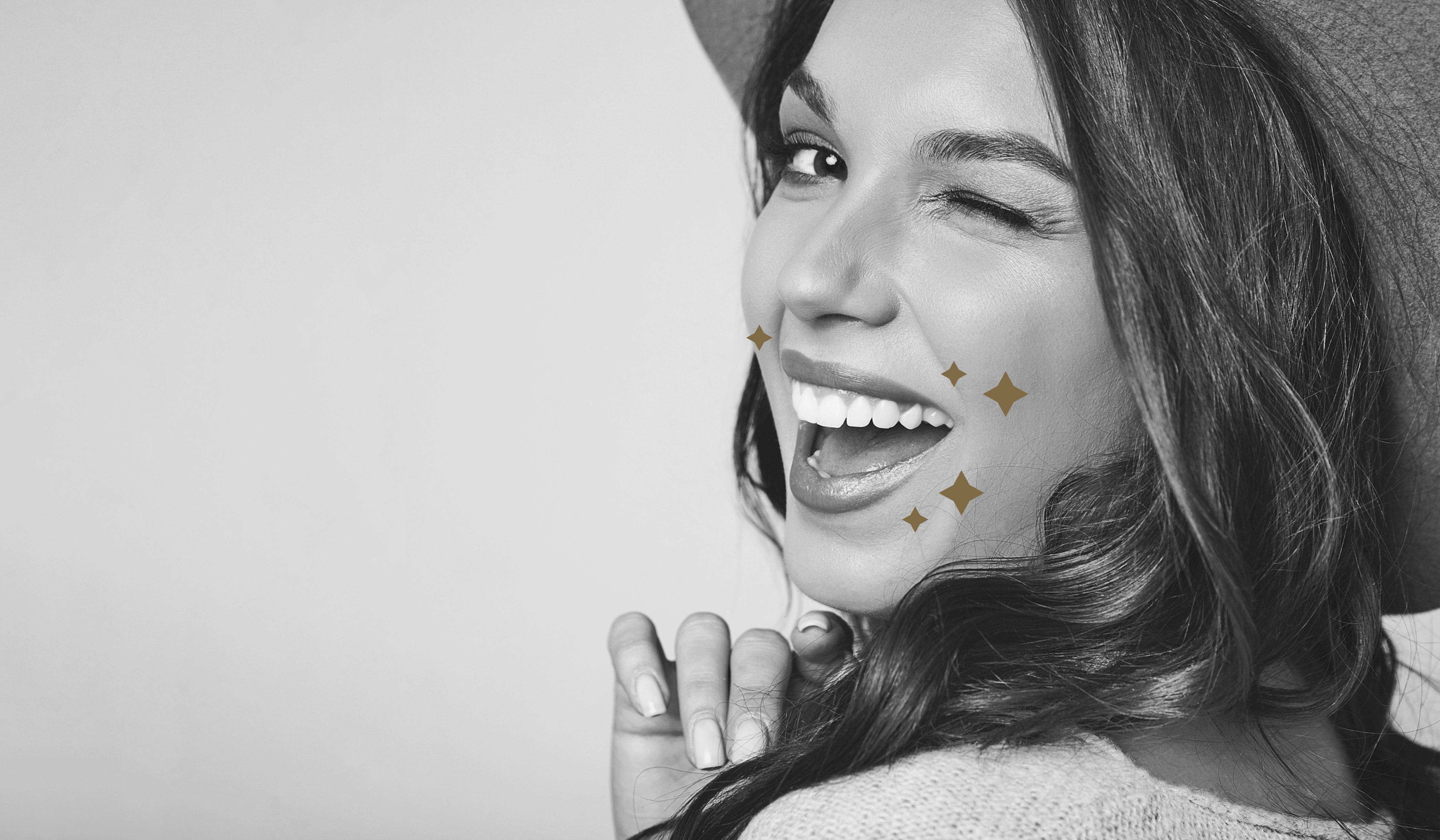 An image of a joyful woman with a big smile, surrounded by white and black stars.