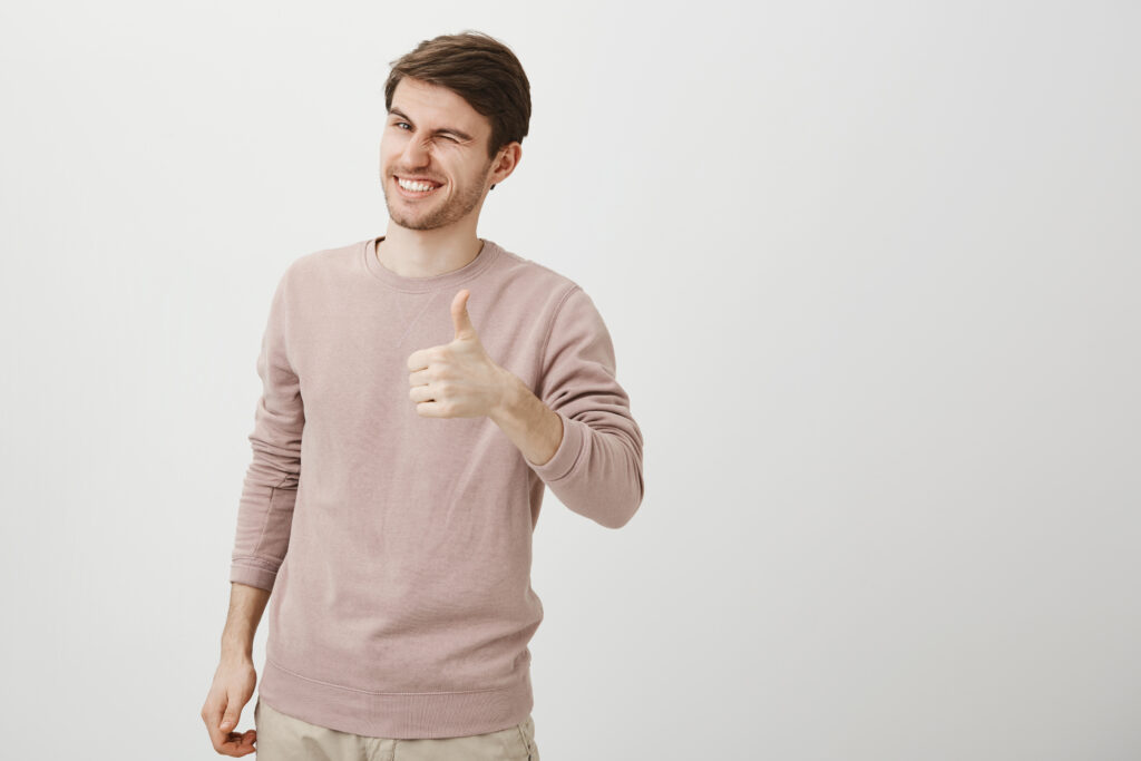 A positive and handsome man showing a thumbs-up gesture.