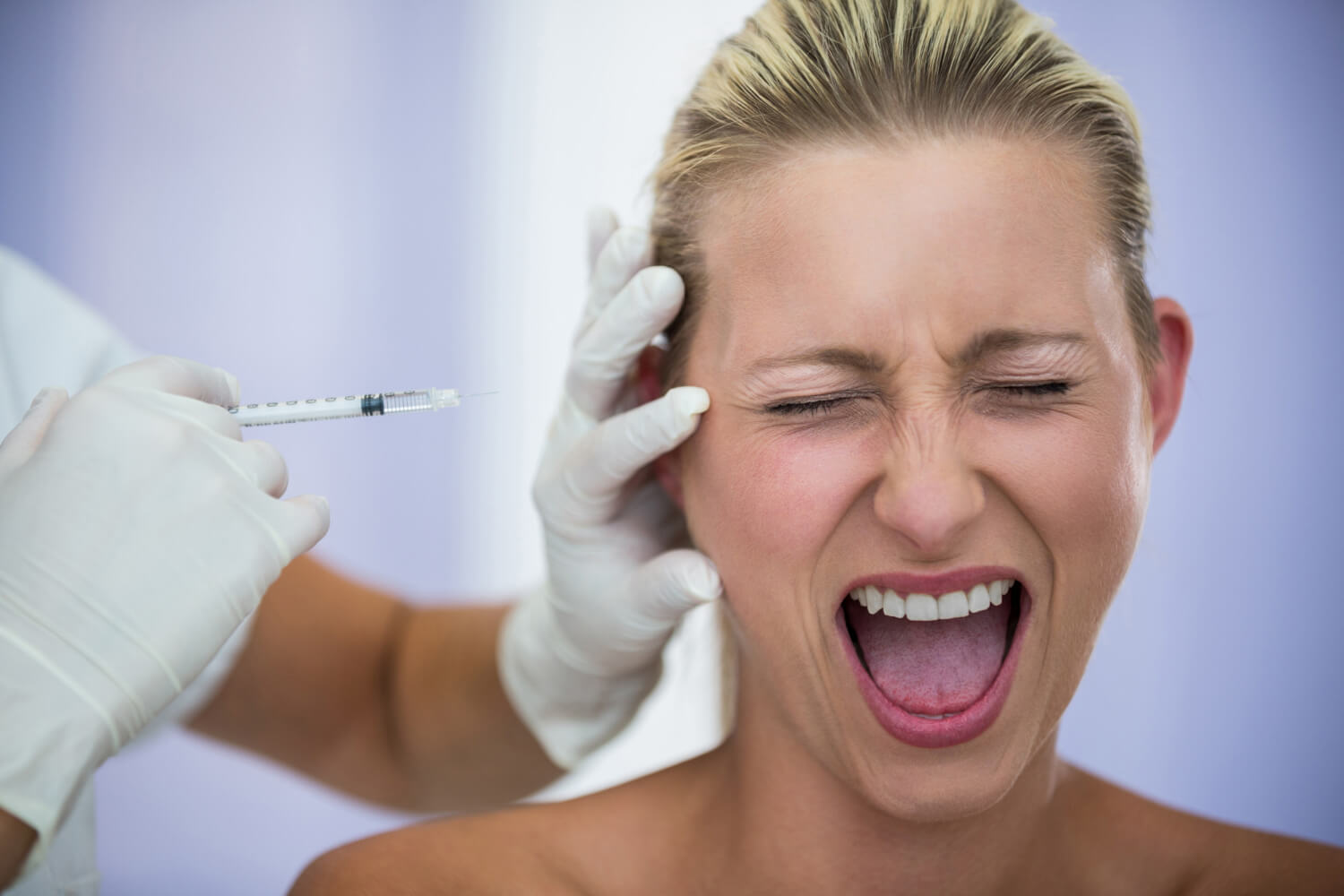 Scared woman receiving an injection during treatment, accompanied by a caring dentist.