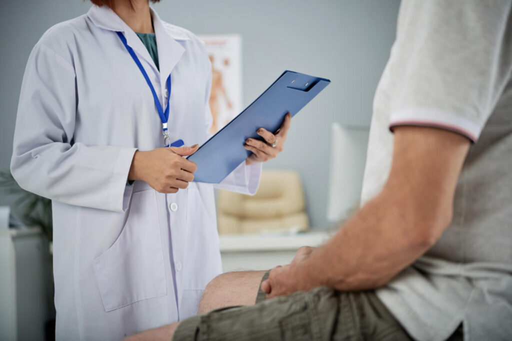 Dentist discussing treatment plan with patient while reviewing notes on a tablet.