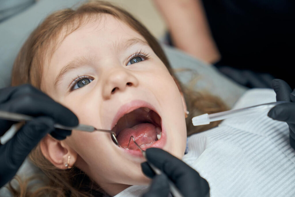 Dentist examining the condition of a young patient's teeth.